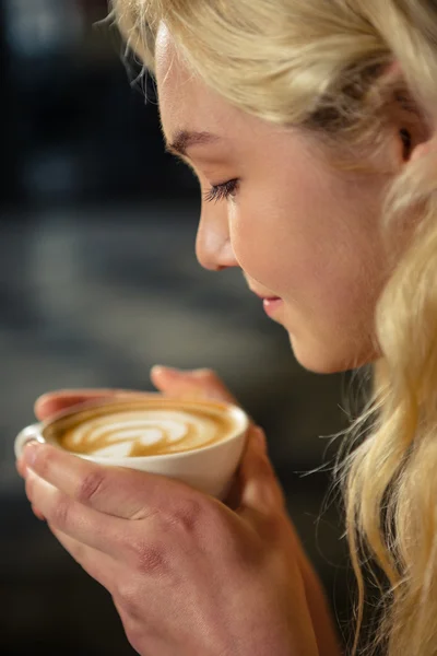 Blonde woman drinking cup of coffee