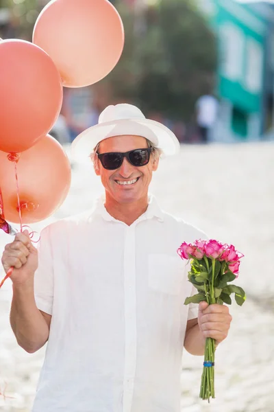 Happy man with balloons and roses