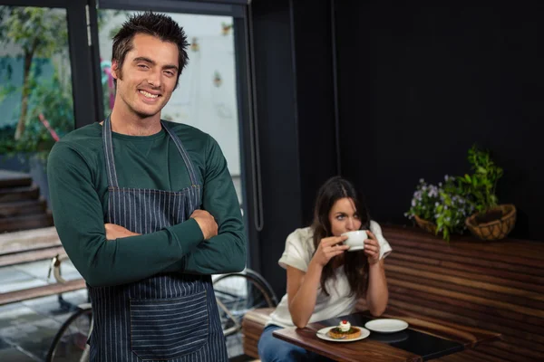 Waiter with arms cross in front of client