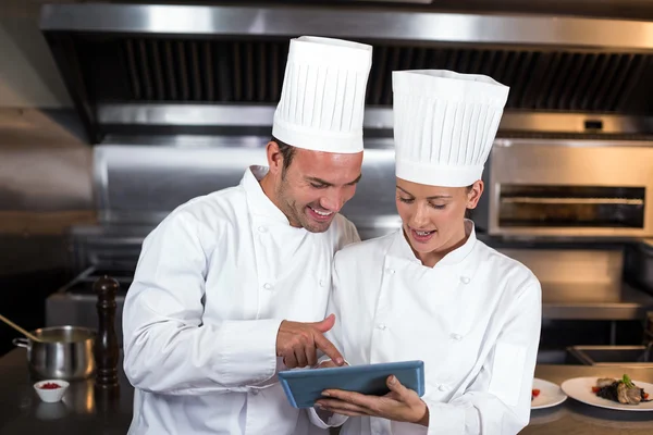 Chefs holding clipboard in kitchen