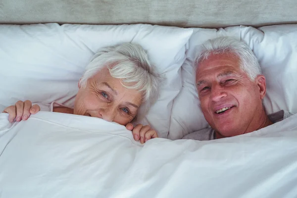 Happy senior couple lying on bed