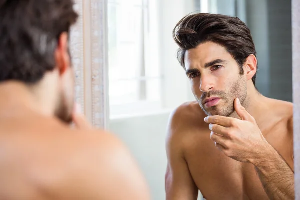 Man checking his stubble in bathroom