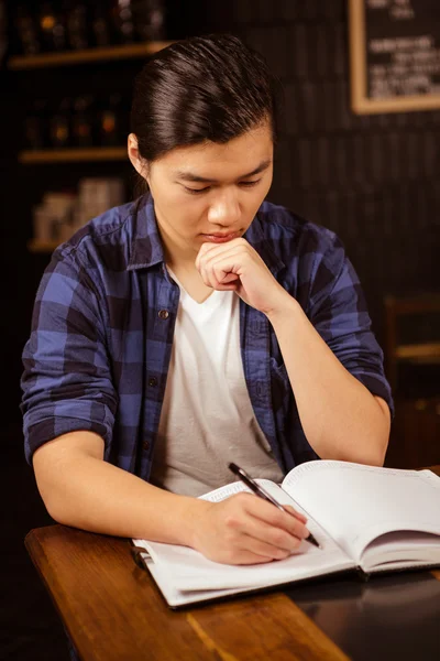 Hipster man writing on planner