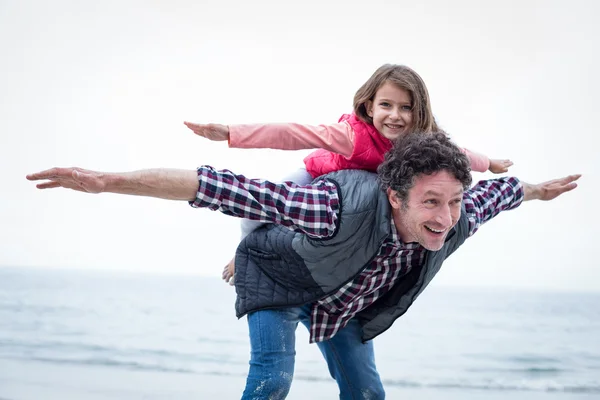 Father carrying daughter on back