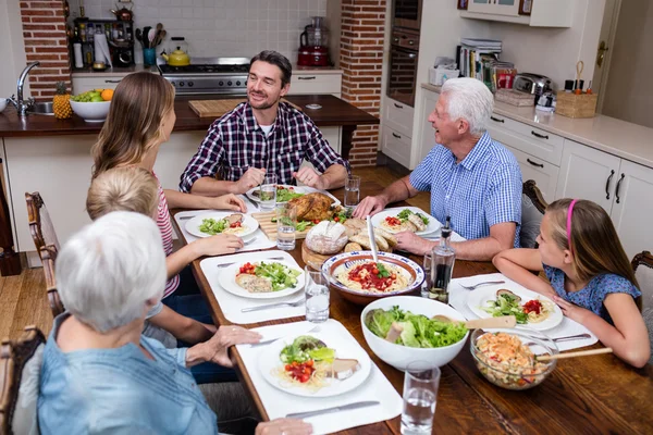 Family talking while having meal in kitchen