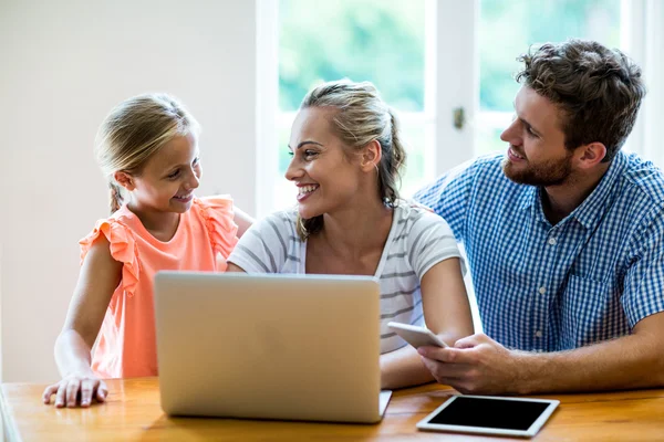 Parents with technologies looking at daughter