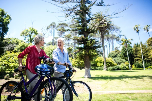 Senior couple walking with bicycles