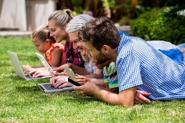 Family using technologies at park