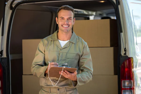 Delivery man writing on a clipboard