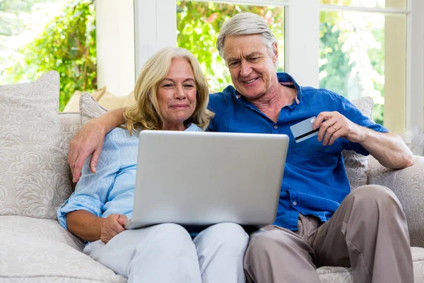 Senior couple using laptop at home