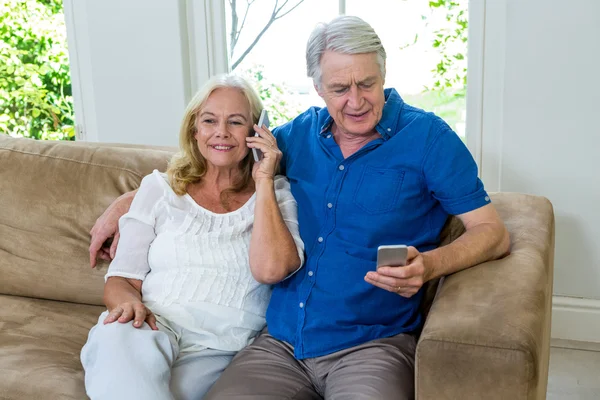 Senior couple using mobile phones