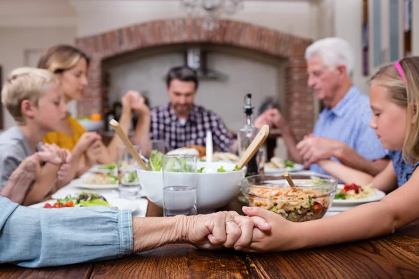 Family praying before having meal