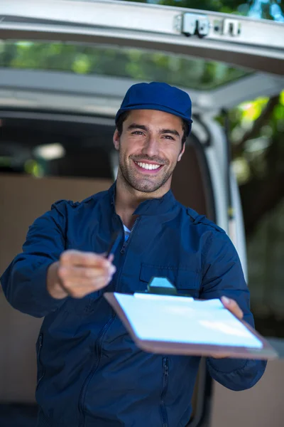 Delivery person giving clipboard for signature