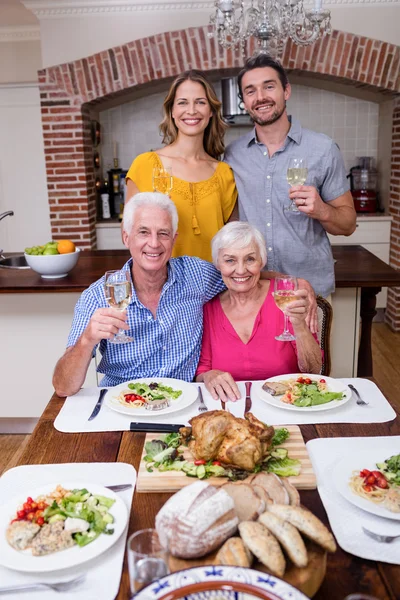 Family holding wine glasses at table