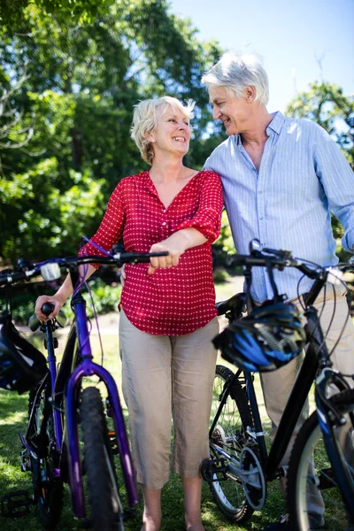 Senior couple standing with bicycles