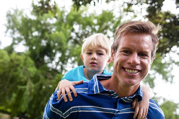 Father giving piggy back to son