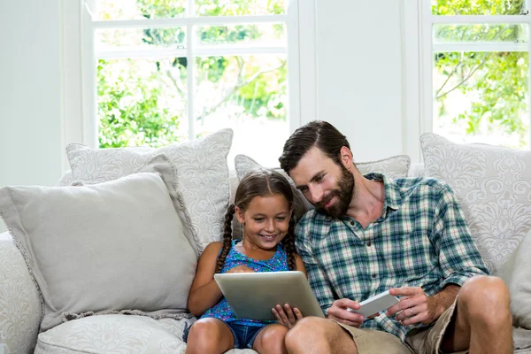 Girl showing digital tablet to father