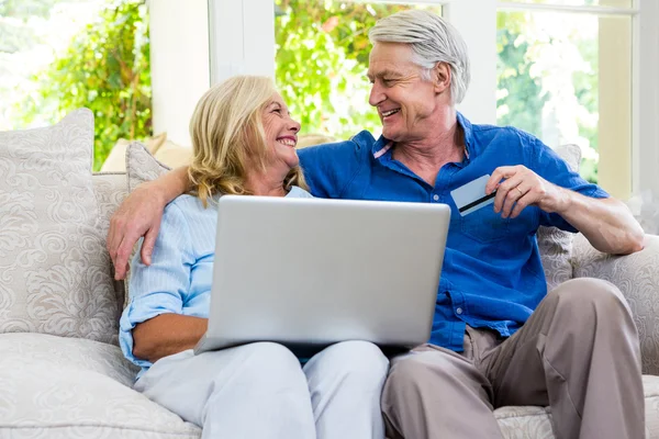 Senior couple using laptop at home