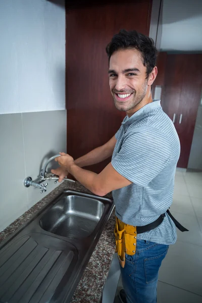 Man fixing faucet with wrench