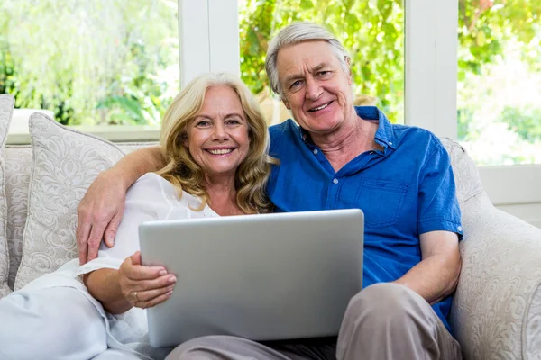 Senior couple with laptop at home