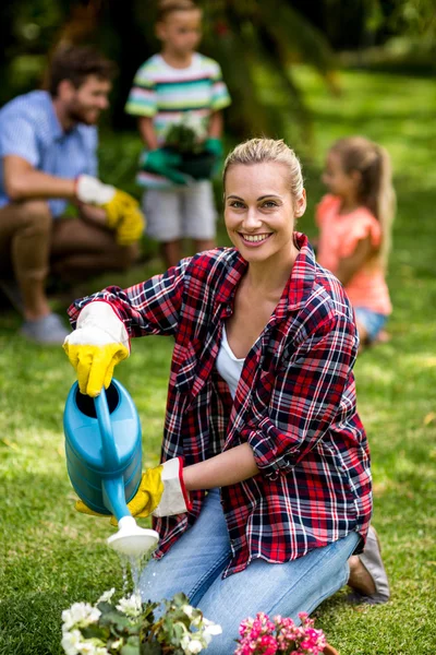 Woman watering can on plants at yard