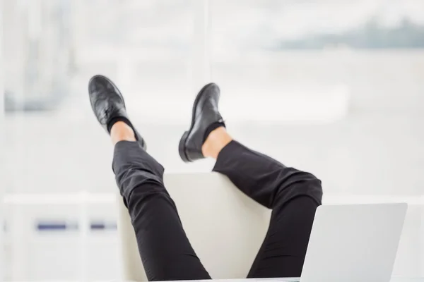 Businessman lying on ground with feet up