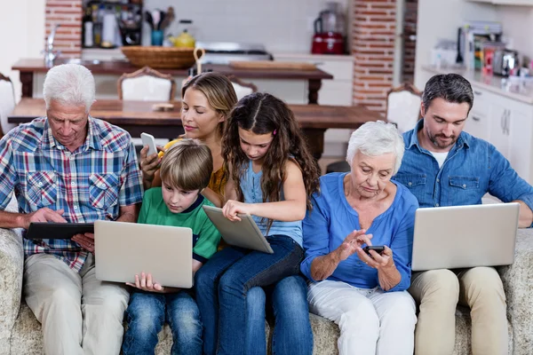 Family using laptops, tablets and phone