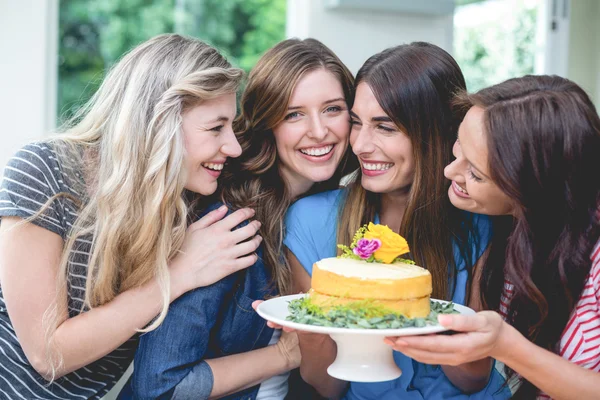 Women holding birthday cake