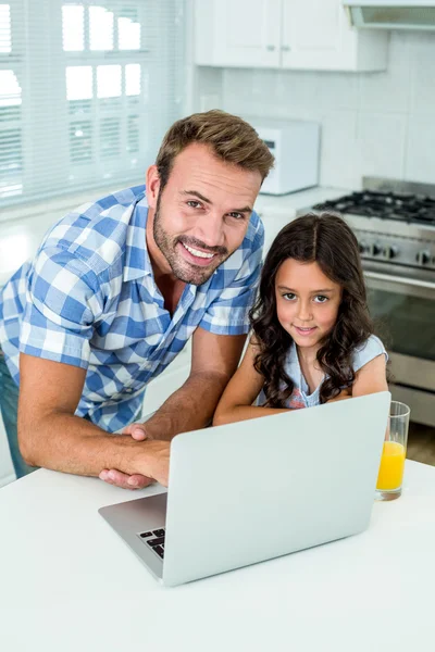 Man with daughter using laptop