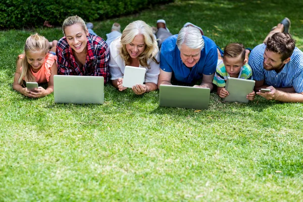 Family with technologies lying in yard