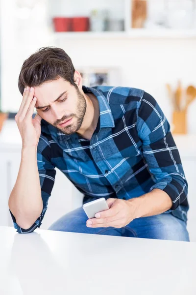 Worried man text messaging on phone