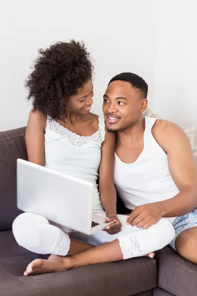 Couple on sofa and using laptop