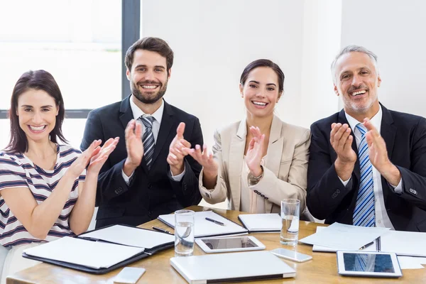 Workers are applauding and smiling