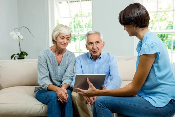 Consultant showing tablet to aged couple