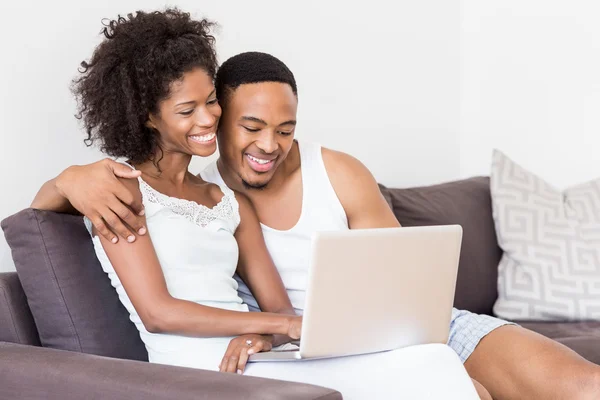 Couple on sofa and using laptop