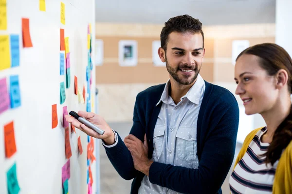 Colleagues looking at white board