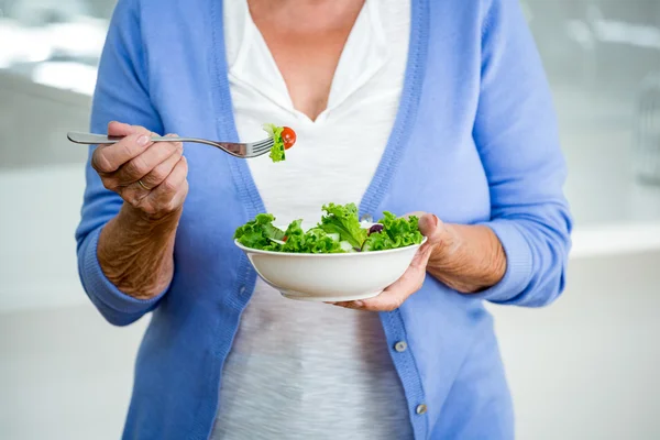 Senior woman eating salad