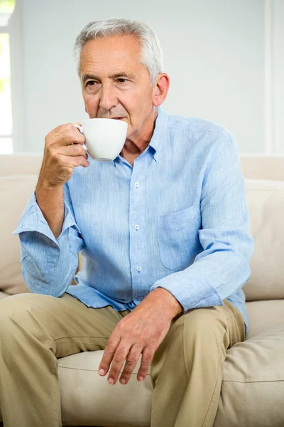 Senior man drinking coffee at home