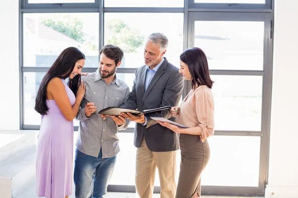 Agent handing over agreement to couple