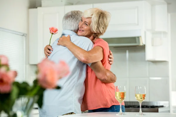 Woman hugging man with rose