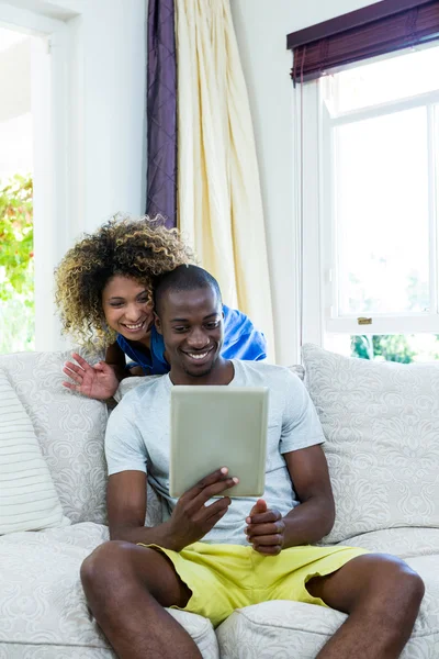 Couple using tablet in living room