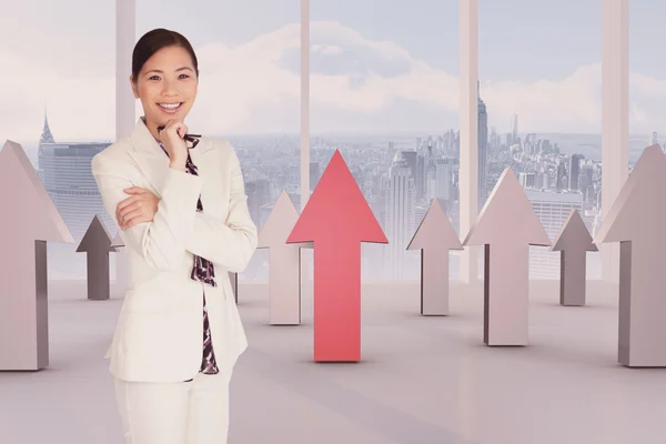 Businesswoman standing in room with windows and arrows