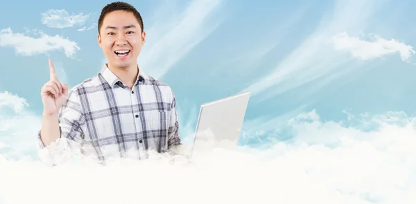 Composite image of happy man holding laptop and pointing
