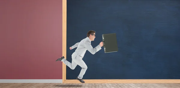 Running businessman in front of chalkboard