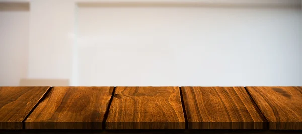 Wooden desk against white wall