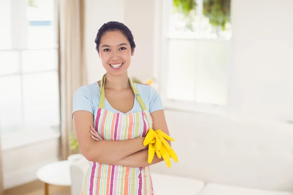 Woman holding gloves and wearing an apron