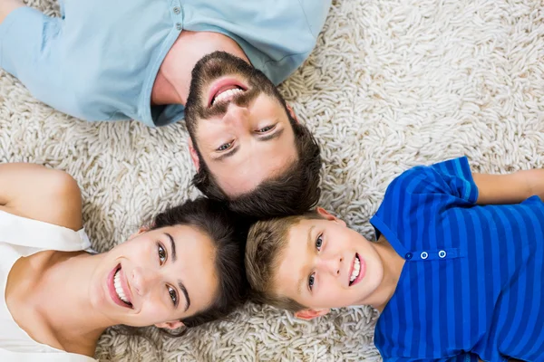 Portrait of parents and son lying on rug