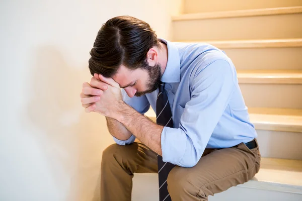 Worried man sitting on stairs