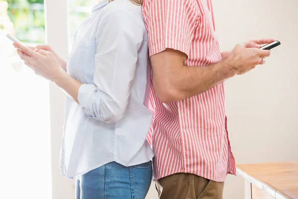 Couple standing back to back