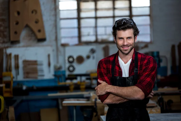 Carpenter smiling and crossing arms